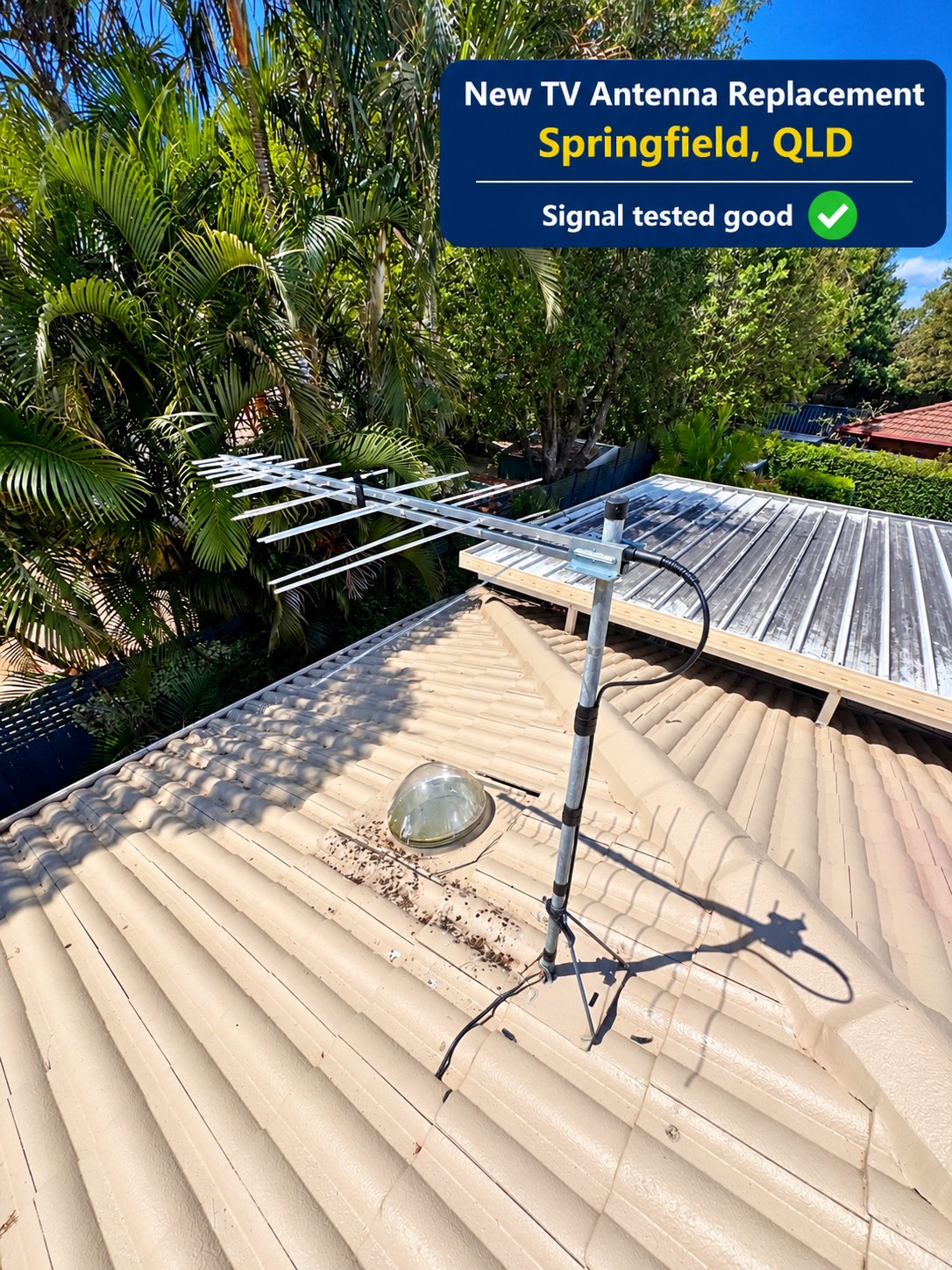 Replacement TV antenna with its mast and cable on a tiled rooftop at Springfield